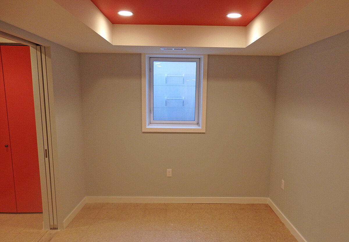 basement bedroom with coffered ceiling and exit window