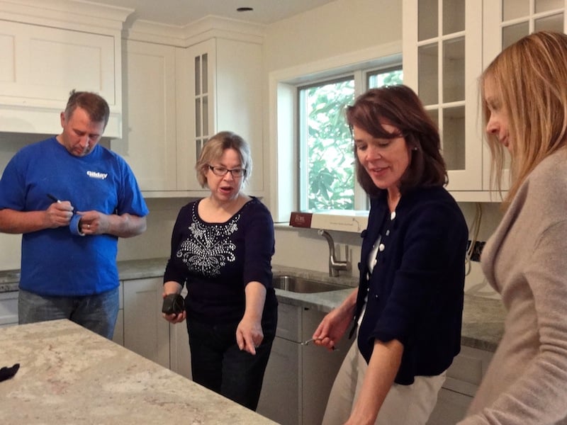 interior designers meet with client on site of design build kitchen remodeling project