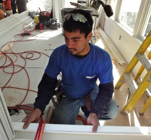 carpenter fits window trim to home-addition-under- construction